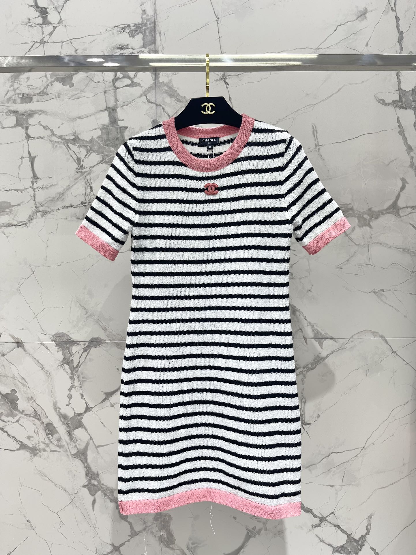 Новинка весны 2024 года от Chanel - универсальный и стройнящий вязаный комбинезон в розовую полоску с круглым вырезом и короткими рукавами, с вышивкой логотипа на груди.