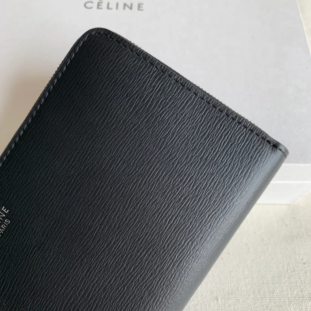 Длинный кошелек Celine на молнии — черный с узором в виде ряби на воде.