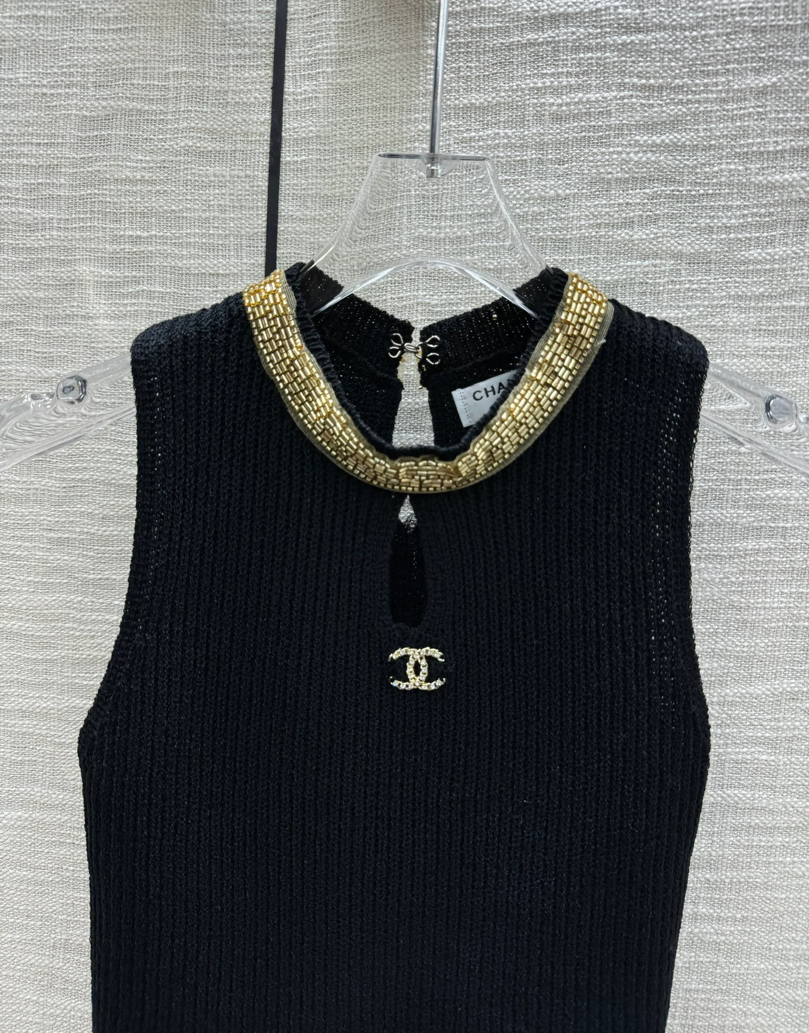 Chanel 2403 - Вязаный жилет с массивным металлическим логотипом, украшенным бусинами, на вырезе горловины - Черный