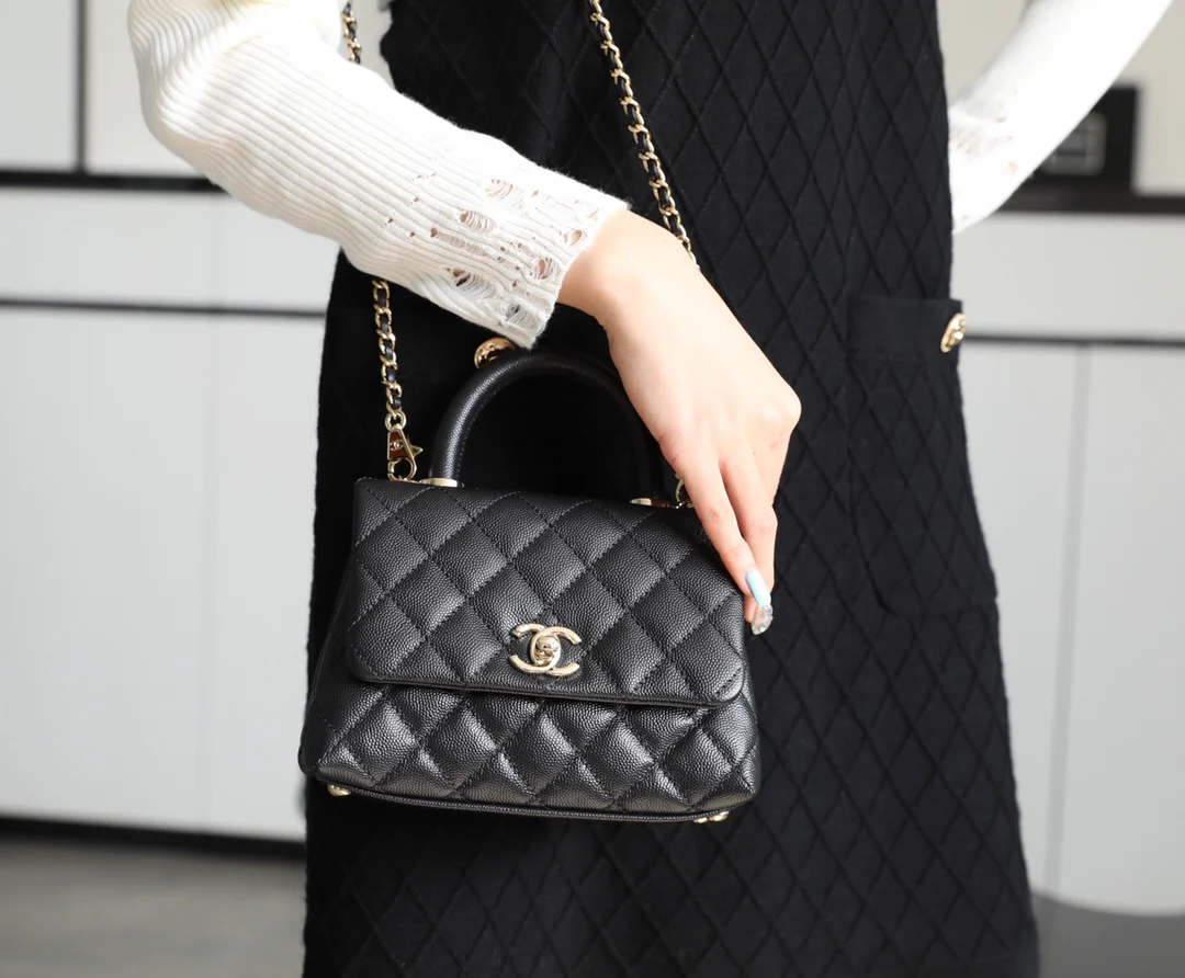 Мини-сумка Chanel Coco Handle — черная кожа с золотистой пряжкой.