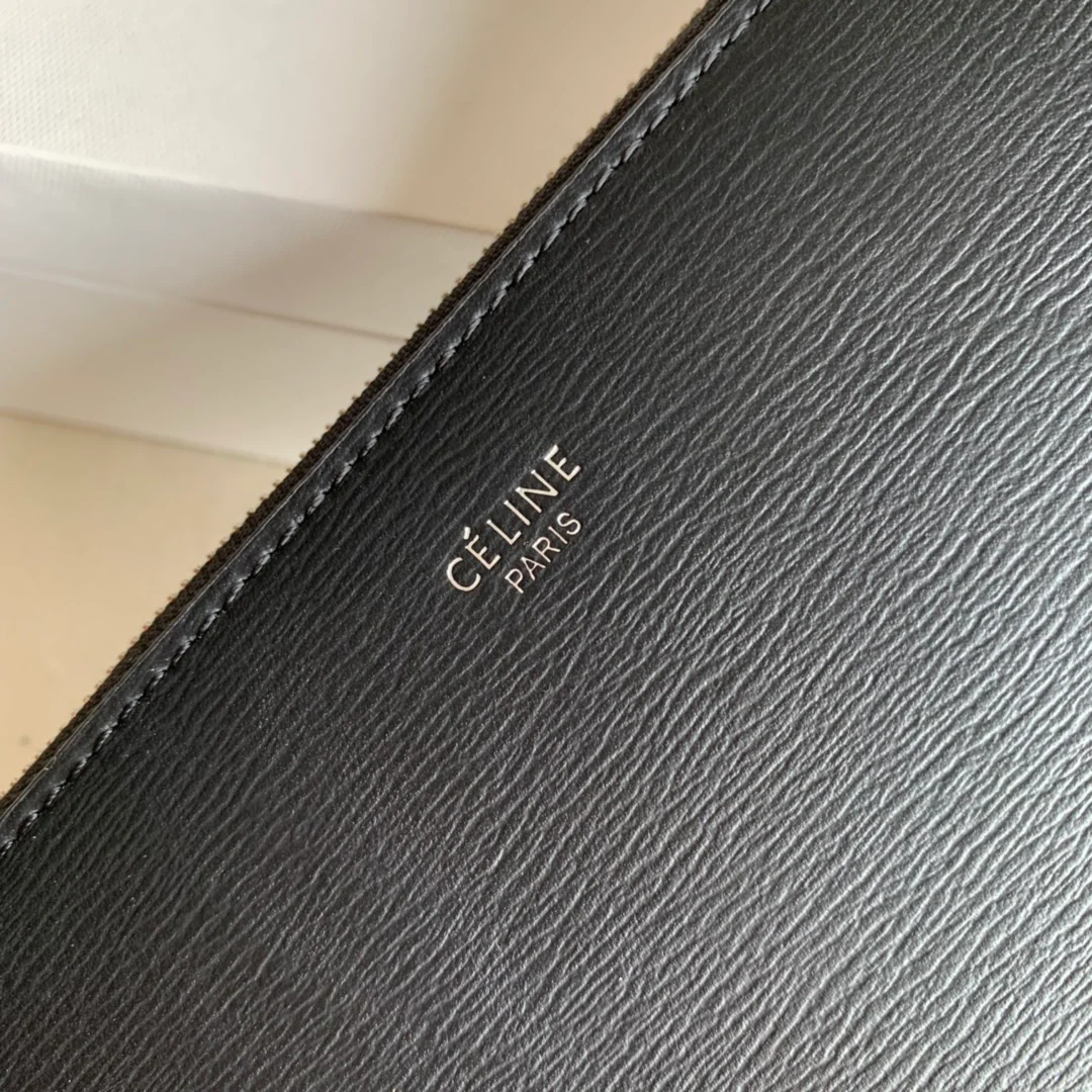 Длинный кошелек Celine на молнии — черный с узором в виде ряби на воде.