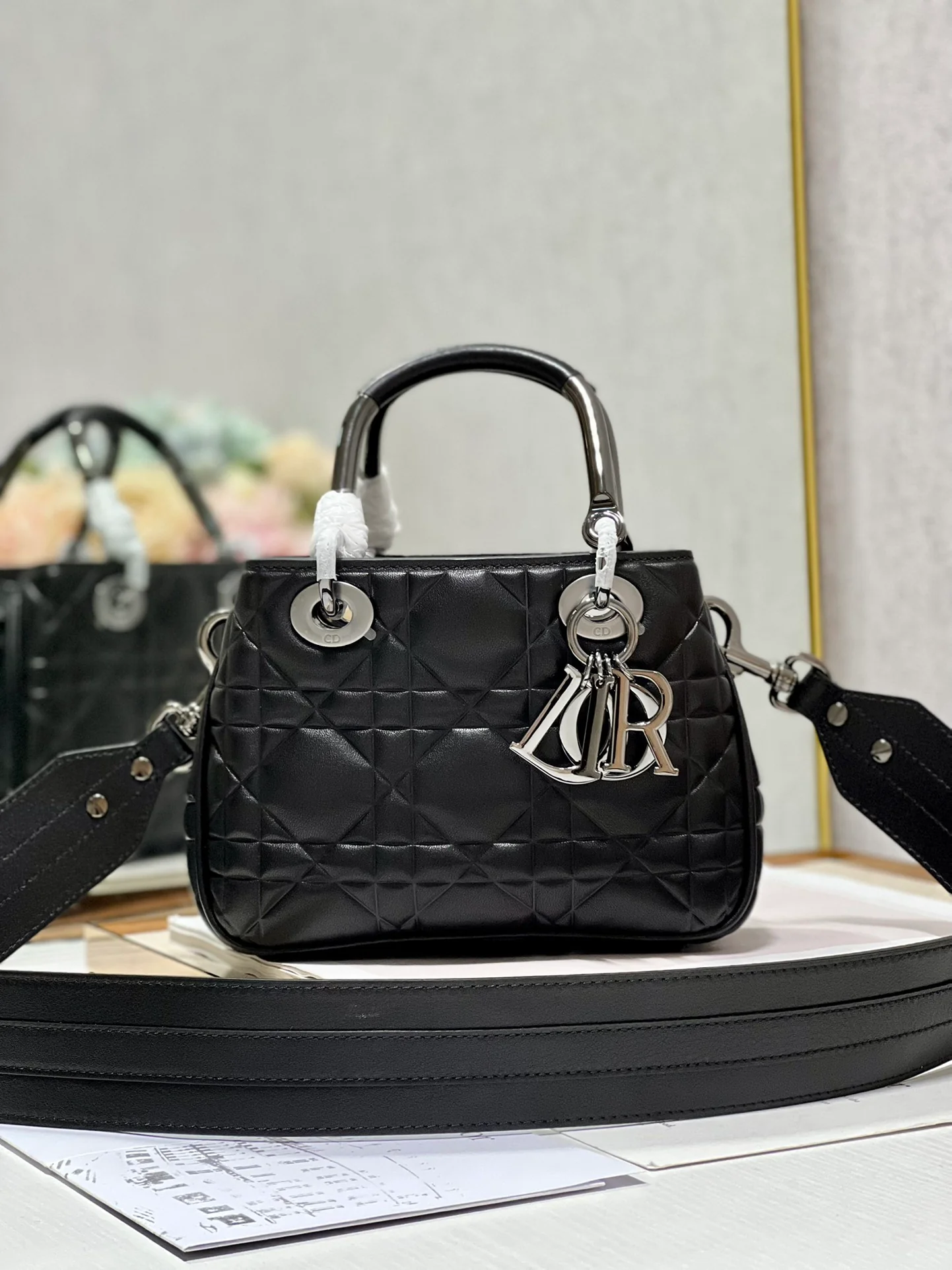 Сумочка Dior Lady 95 22, маленькая, черная, с пряжкой в ??виде пистолета.