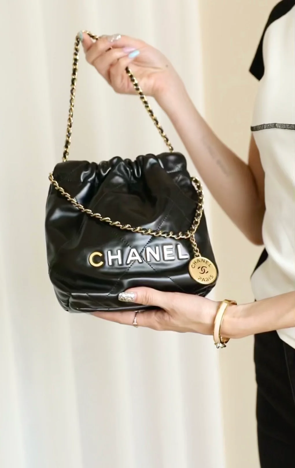 Мини-сумочка Chanel 22 – черная с золотой фурнитурой.