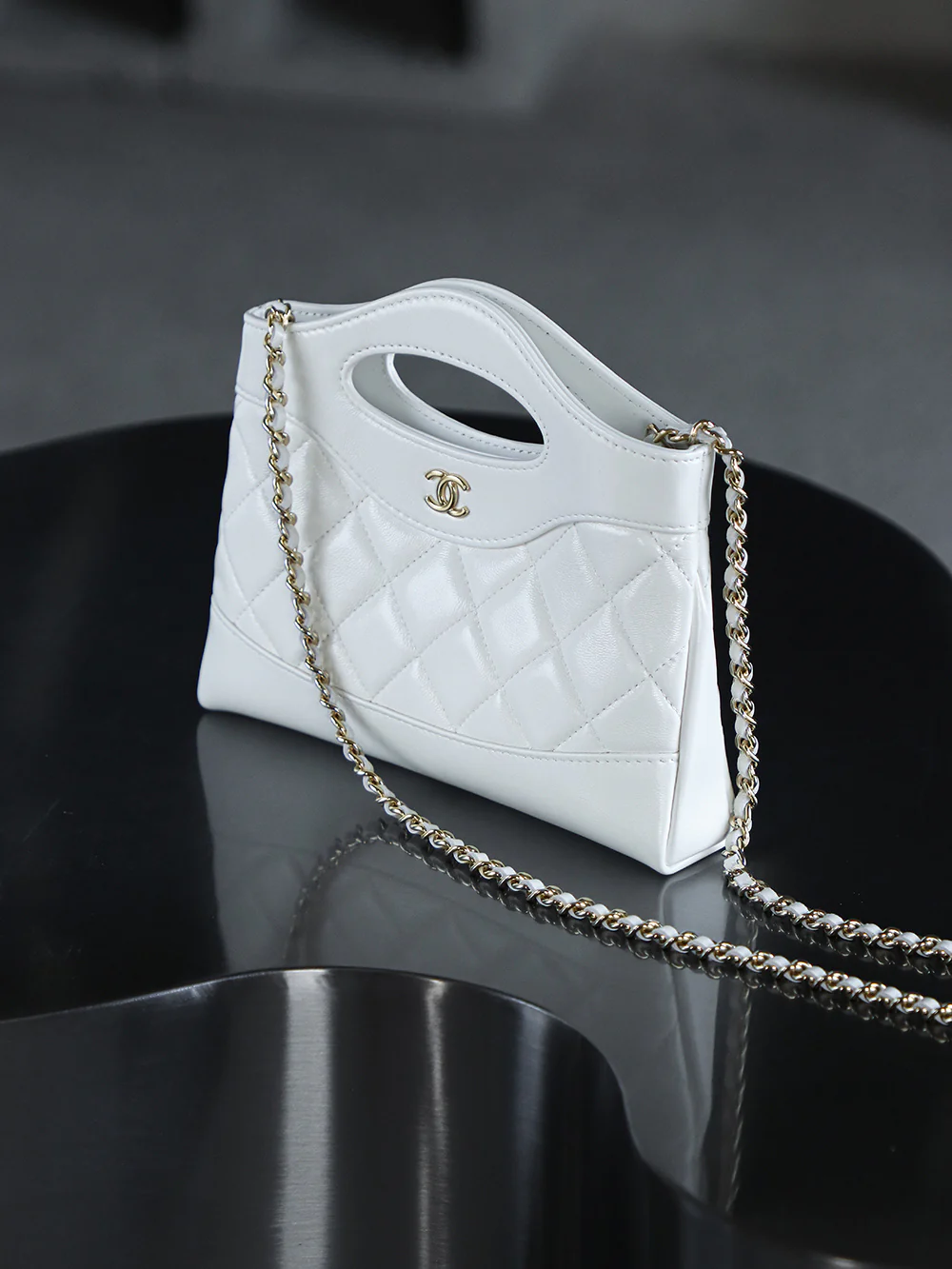 Сумка Chanel Nano 31, горизонтальный вариант, белая с пряжкой из светло-золотистого металла.