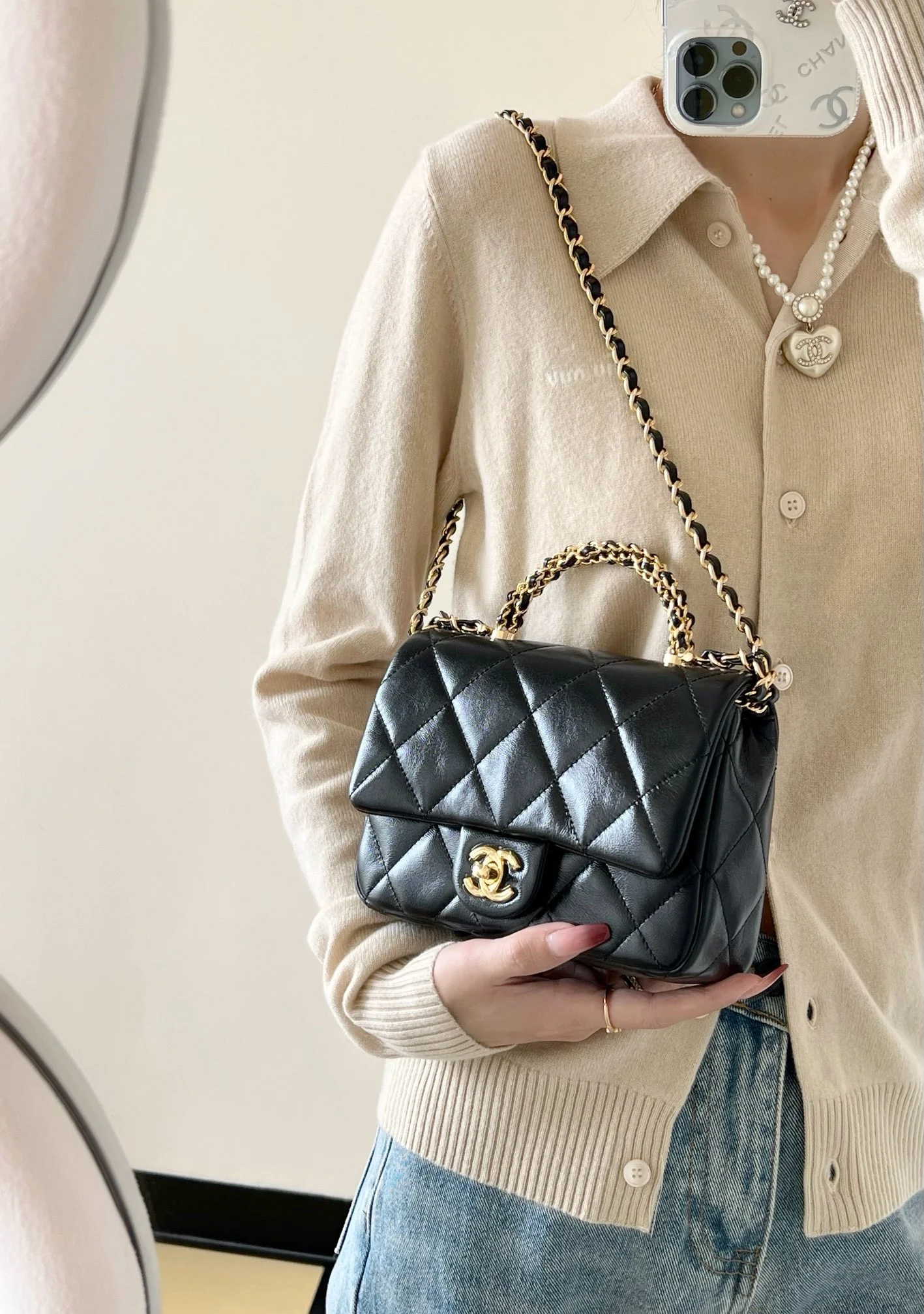 Маленькая черная сумка Chanel с клапаном и поворотной ручкой.