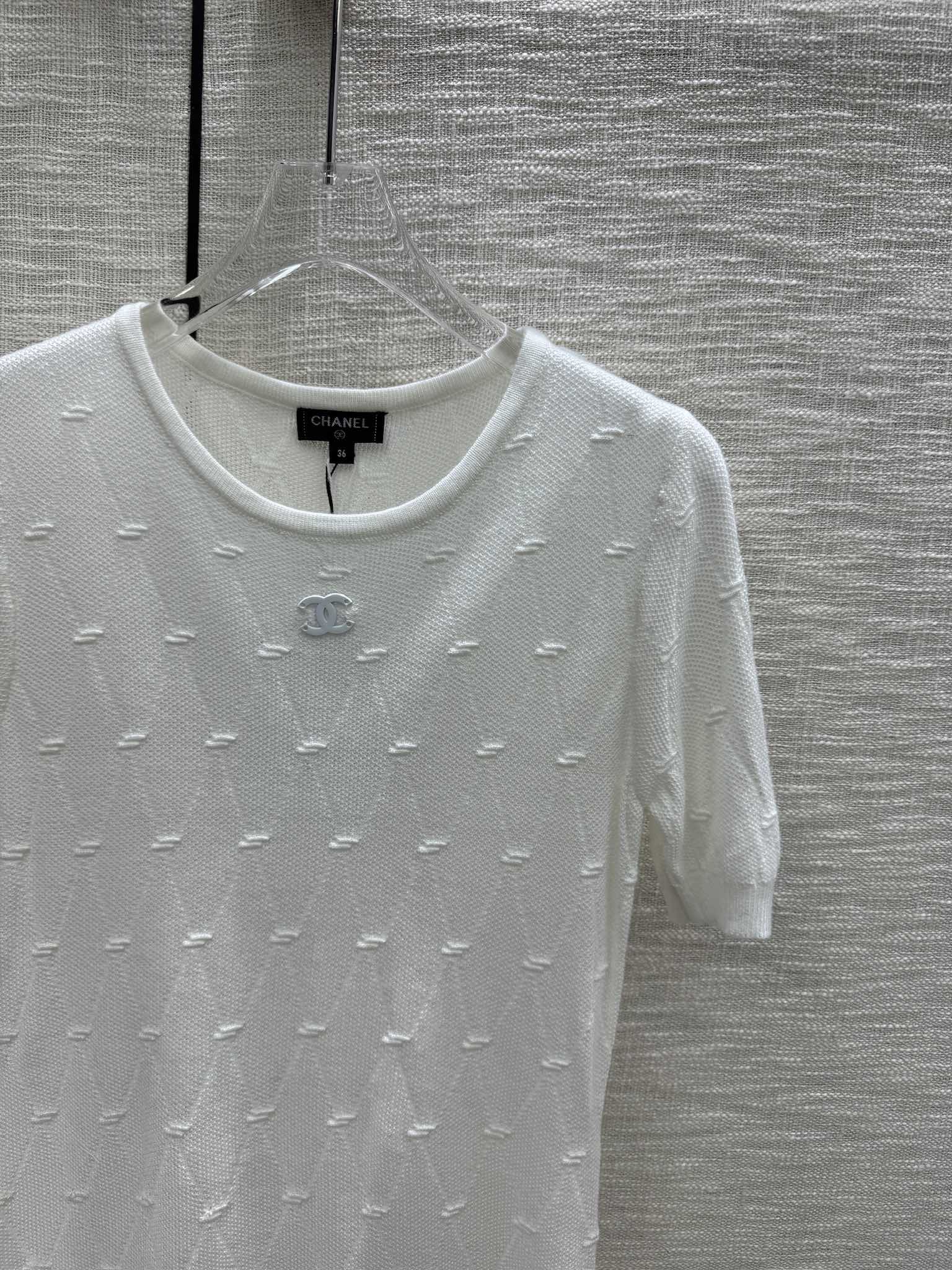 Новая коллекция Chanel Весна/Лето 2024: трикотажное платье с короткими рукавами и ромбовидным узором, белое.