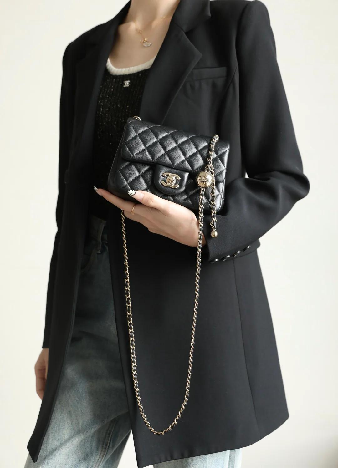 Сумка-шар Chanel из 25-каратного золота с регулируемой застежкой, черная с фурнитурой из светлого золота.