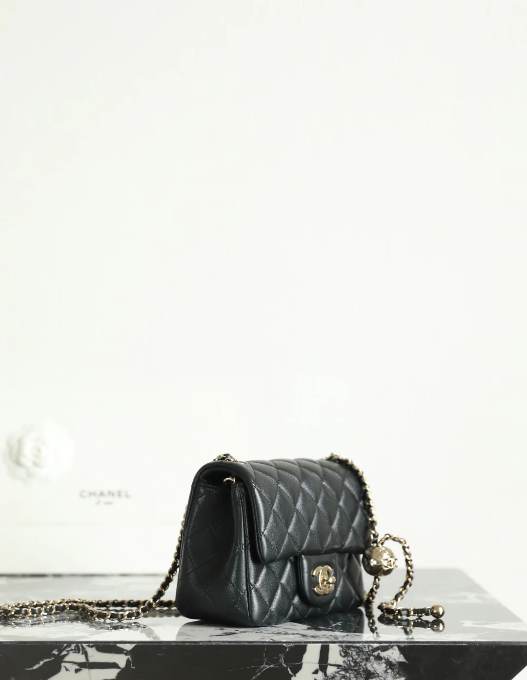 Сумка-шар Chanel из 25-каратного золота с регулируемой застежкой, черная с фурнитурой из светлого золота.