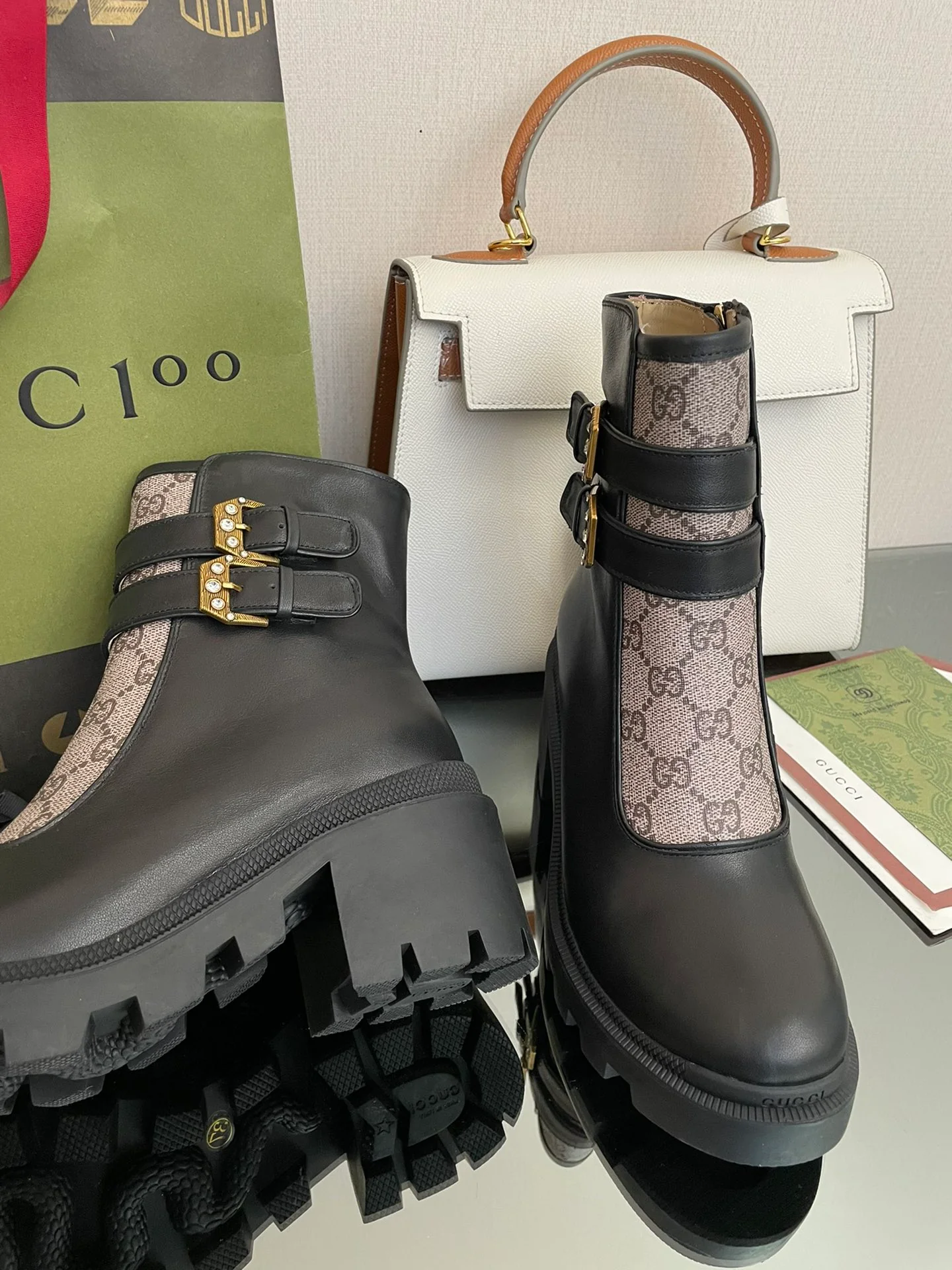 Сапоги Gucci на массивном каблуке до середины икры с монограммой — черные и бежевые.