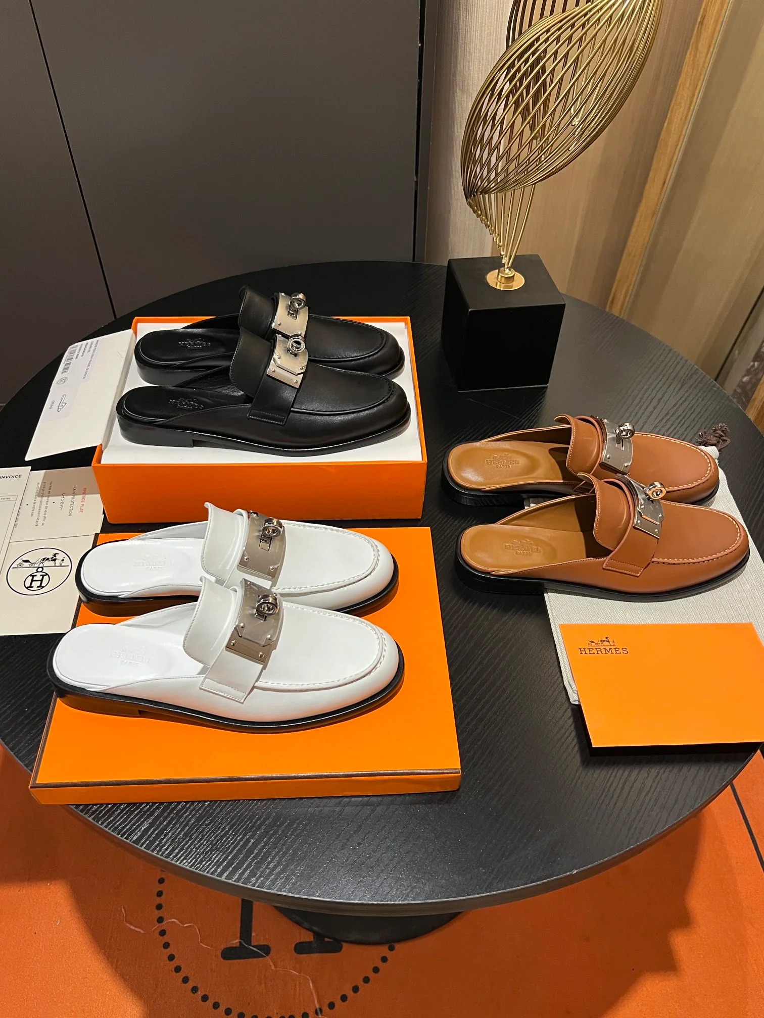 Мюли Hermes 2024 с металлической пряжкой в ??виде буквы H — белые.