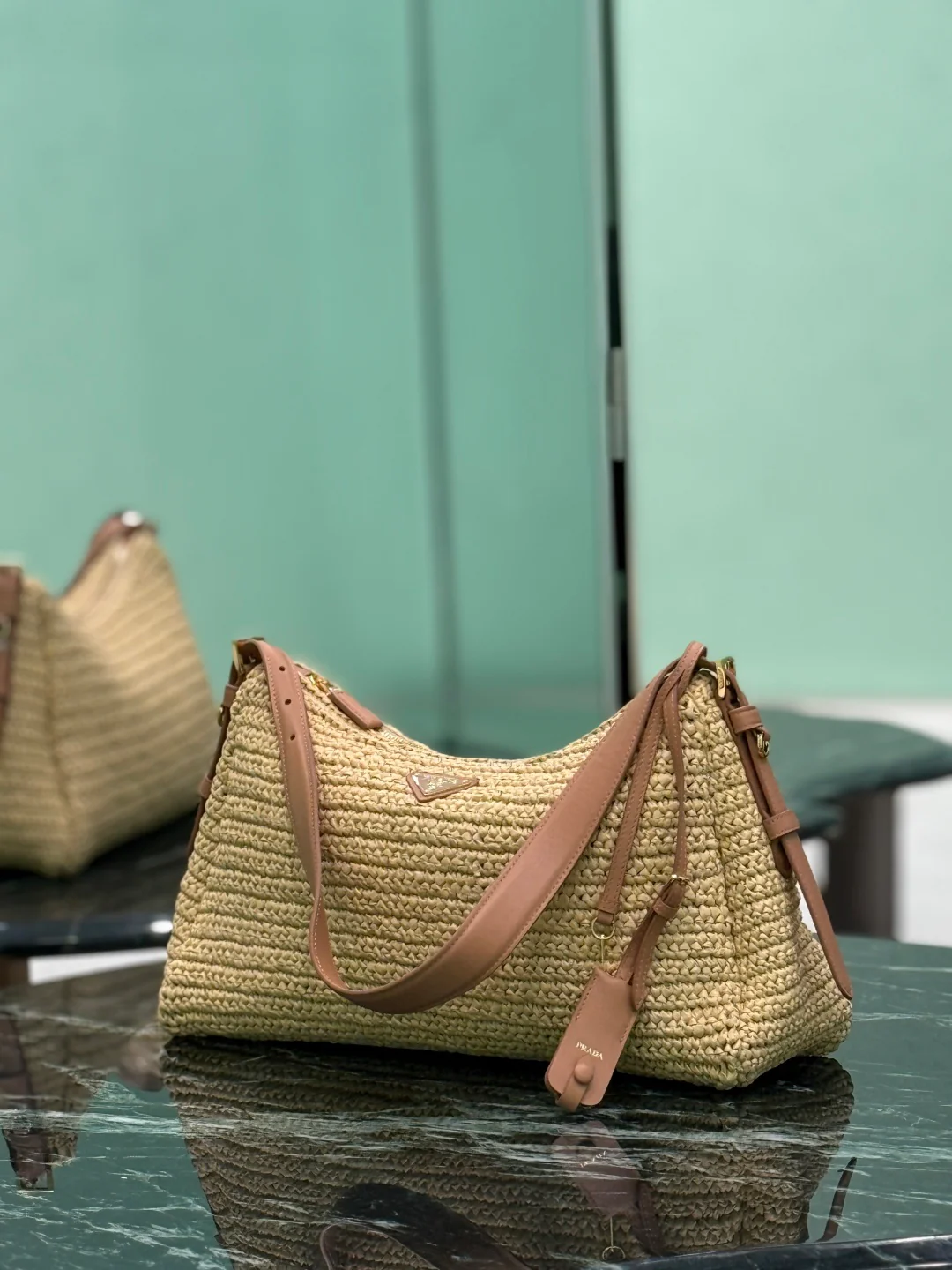 Сумка Prada Aimee из соломы, которую можно носить под мышкой.