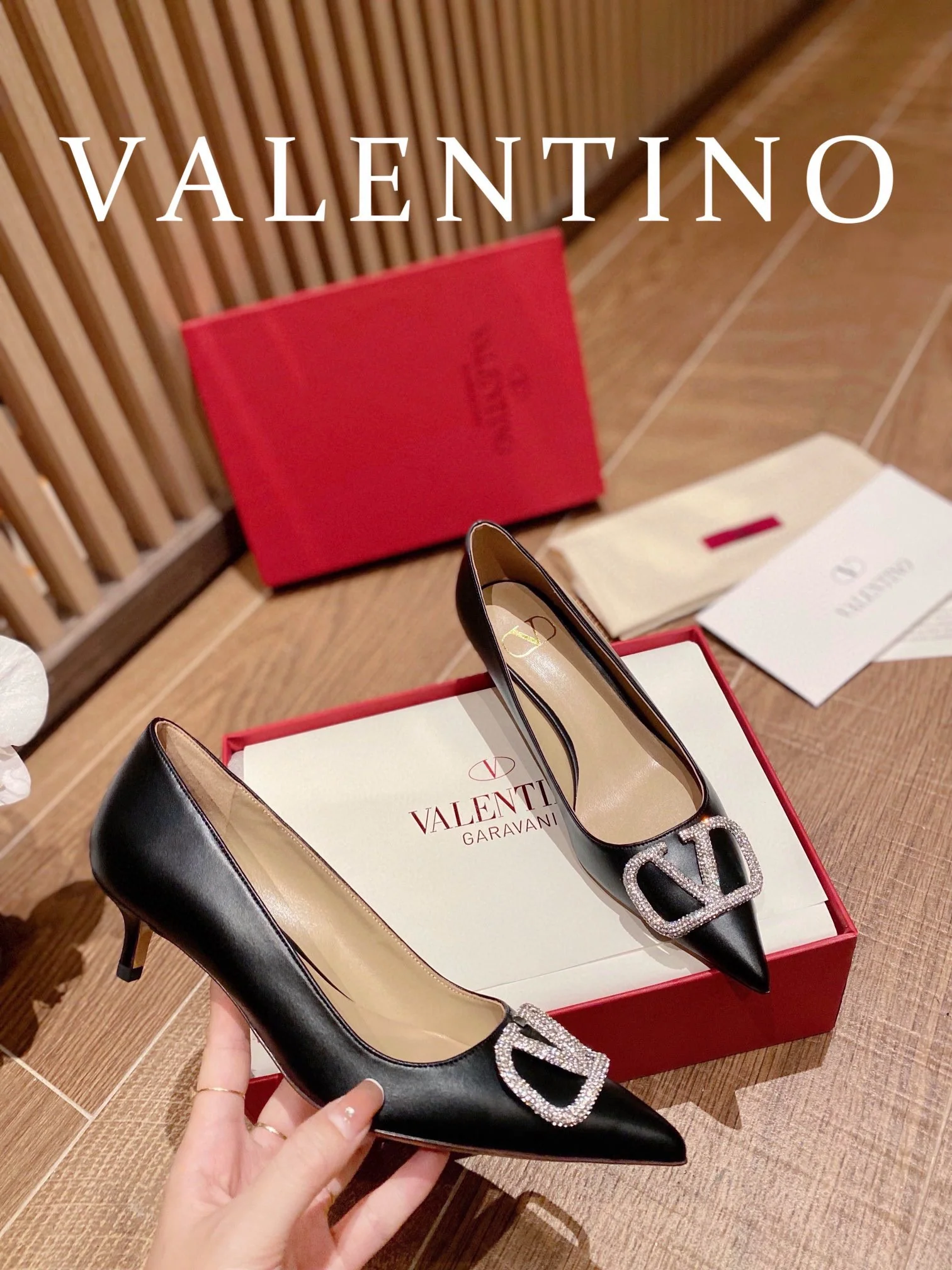 Туфли Valentino на каблуке с V-образным вырезом и бриллиантовой пряжкой — черные.