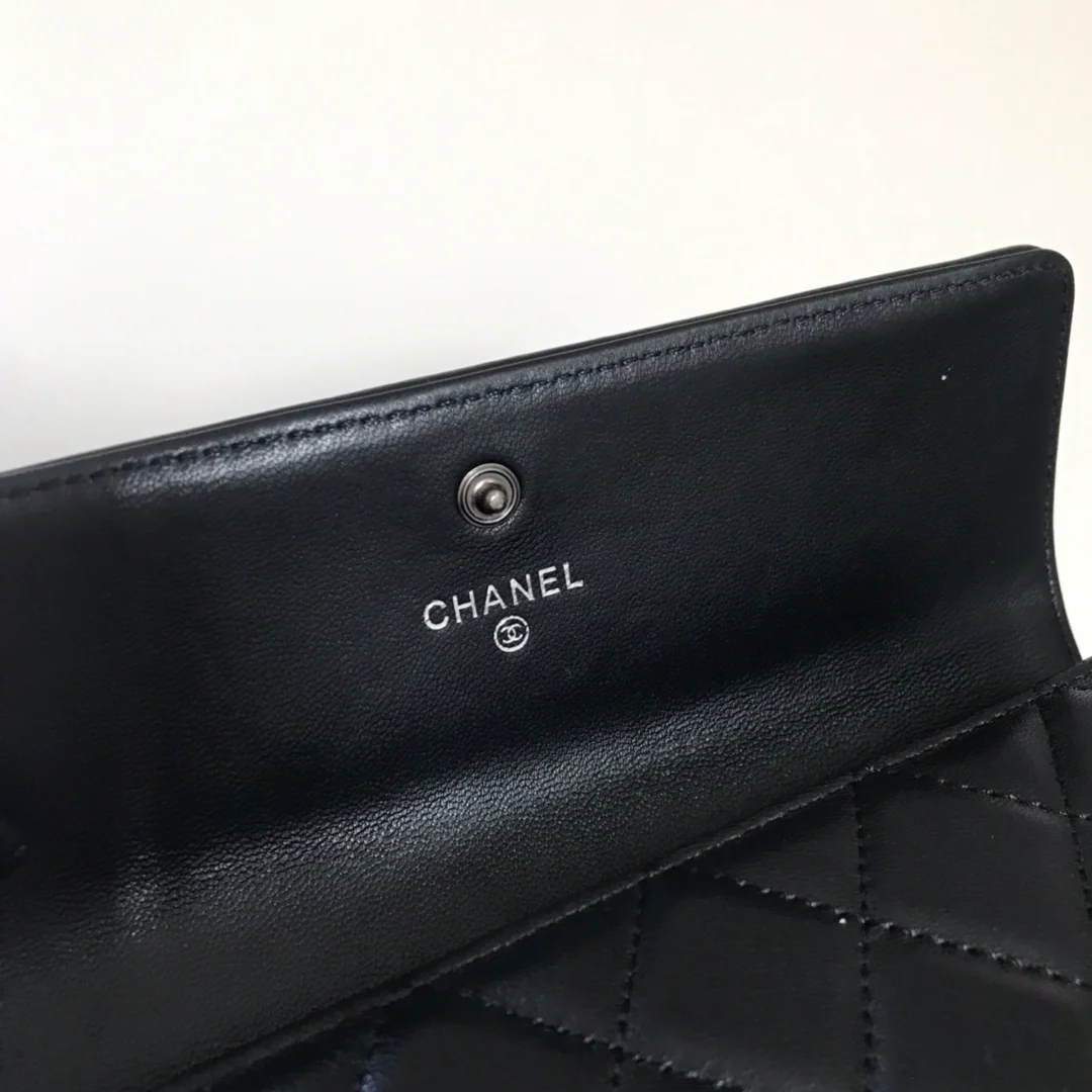 Кошелек-портмоне Chanel Le Boy Flip Wallet — из черной овечьей кожи с серебряной пряжкой.