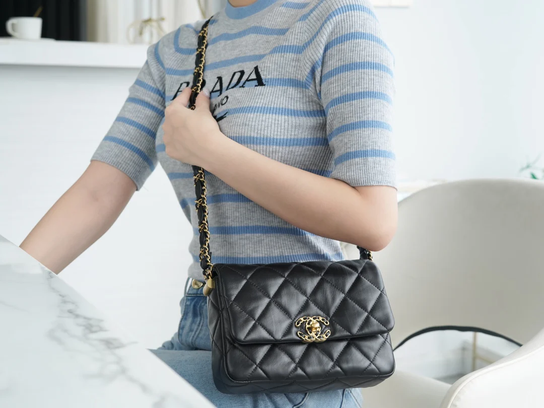 Коллекция Chanel осень/зима - сумка с широким плечевым ремнем и клапаном, черная с золотыми вставками из мятой телячьей кожи.