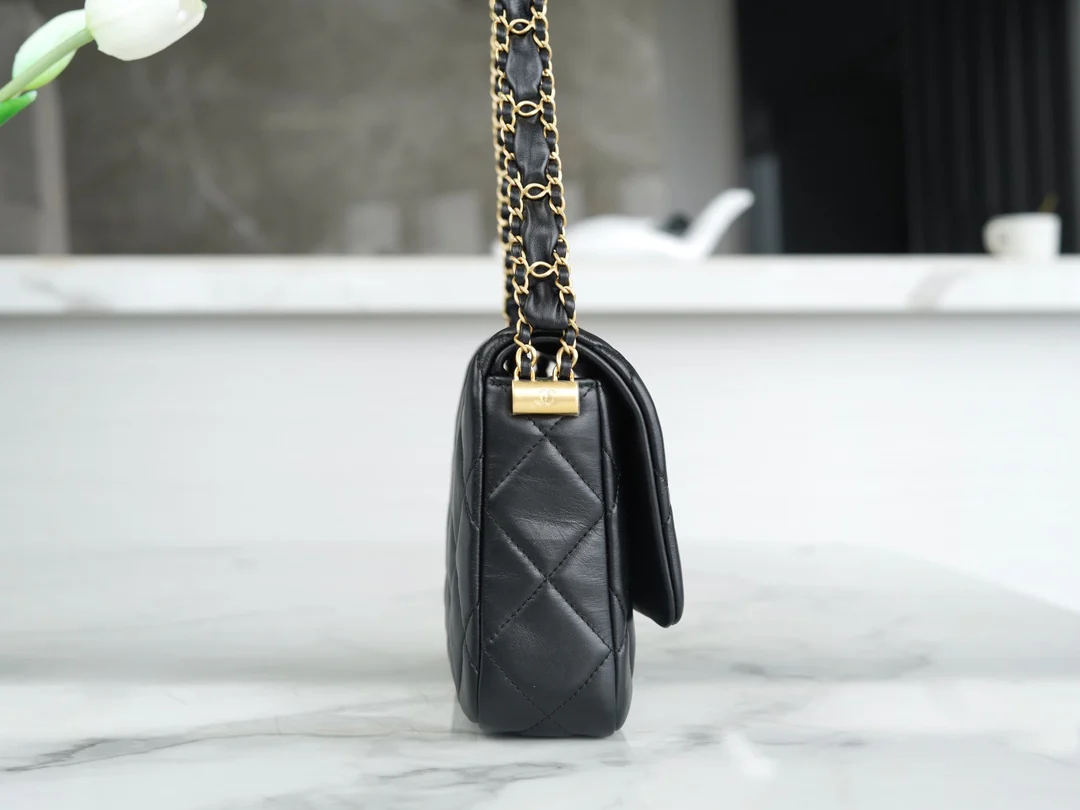 Коллекция Chanel осень/зима - сумка с широким плечевым ремнем и клапаном, черная с золотыми вставками из мятой телячьей кожи.