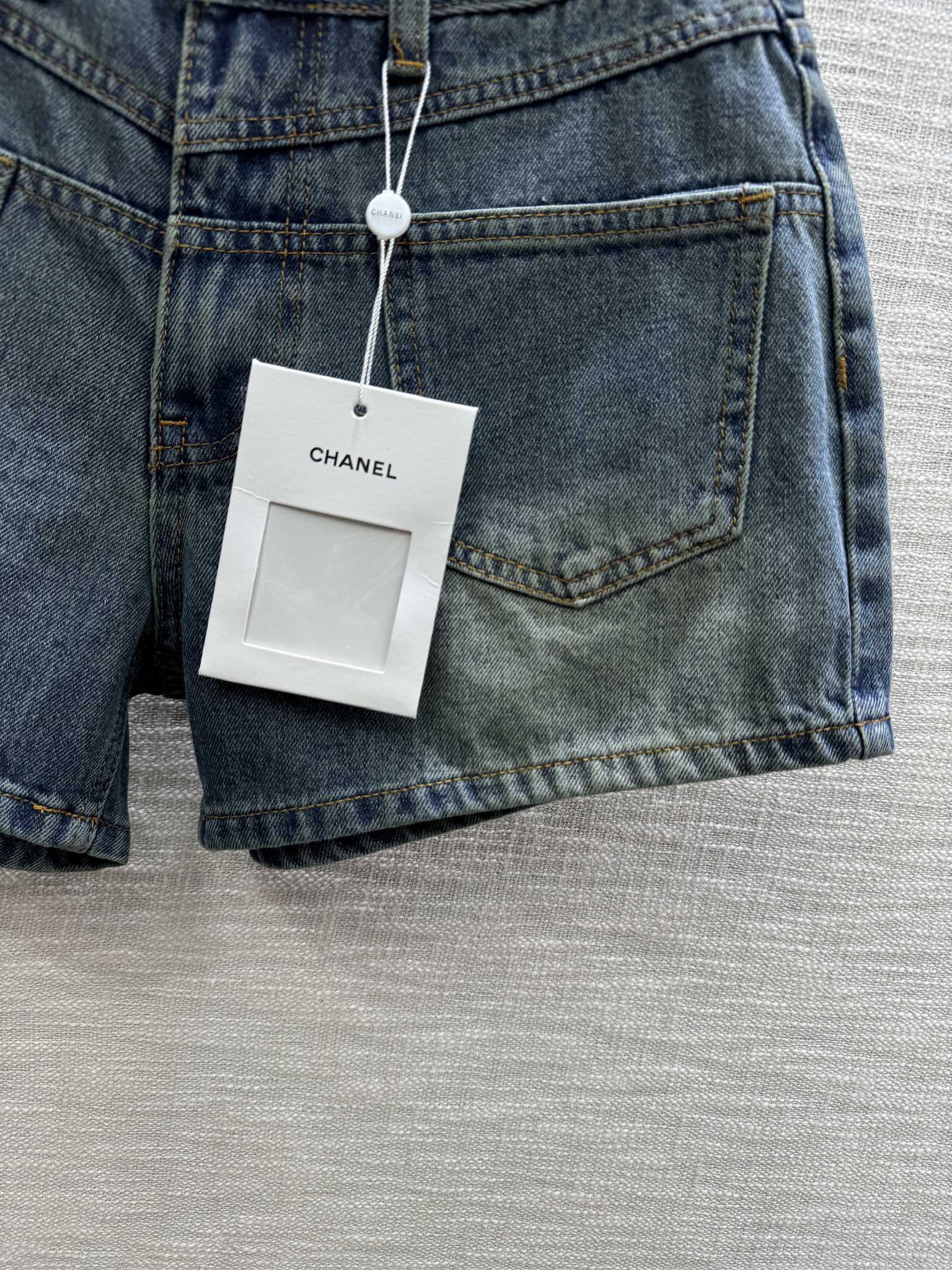 Джинсовые шорты Chanel 2403 с высокой талией и двумя карманами.