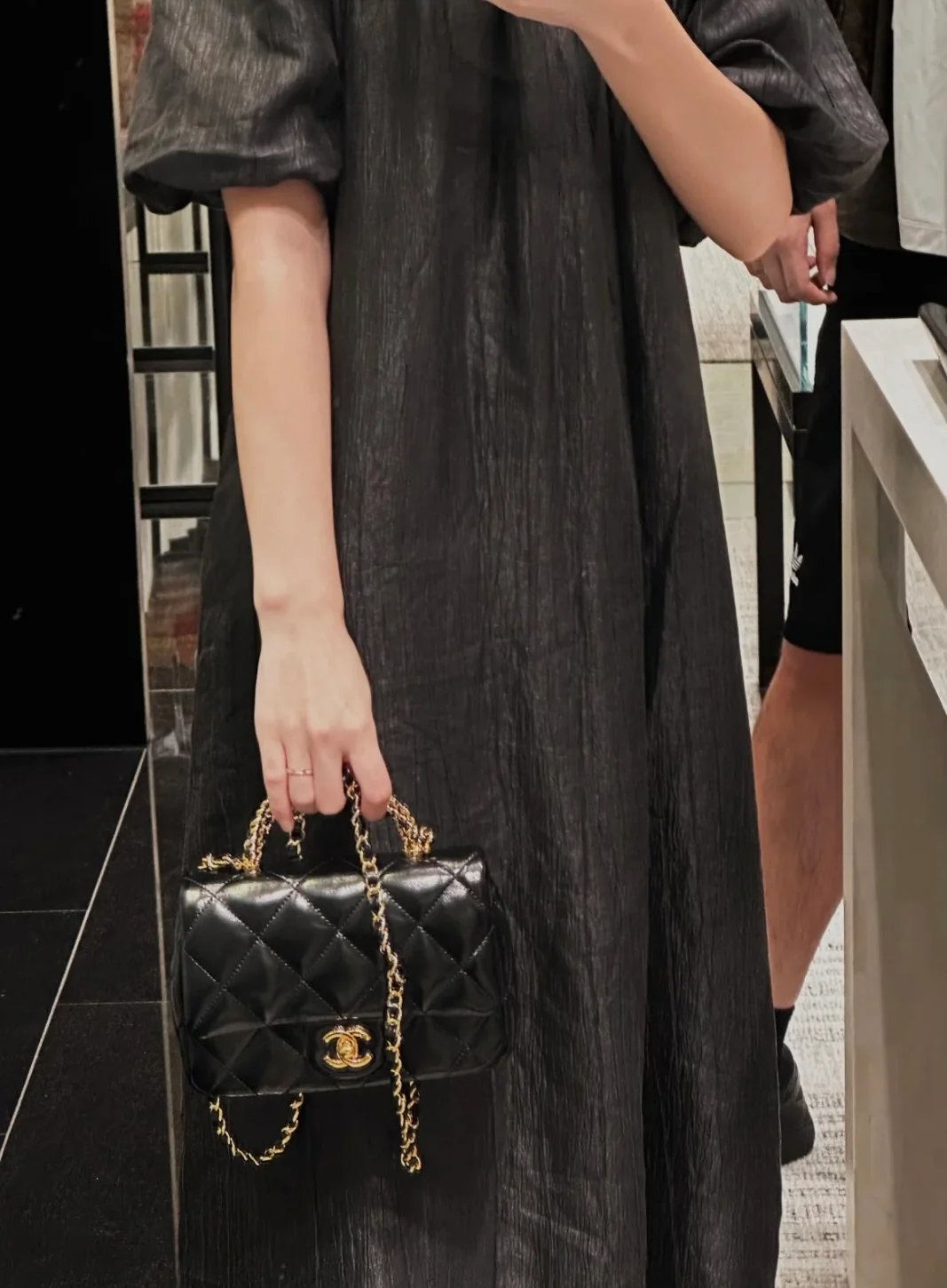 Маленькая черная сумка Chanel с клапаном и поворотной ручкой.