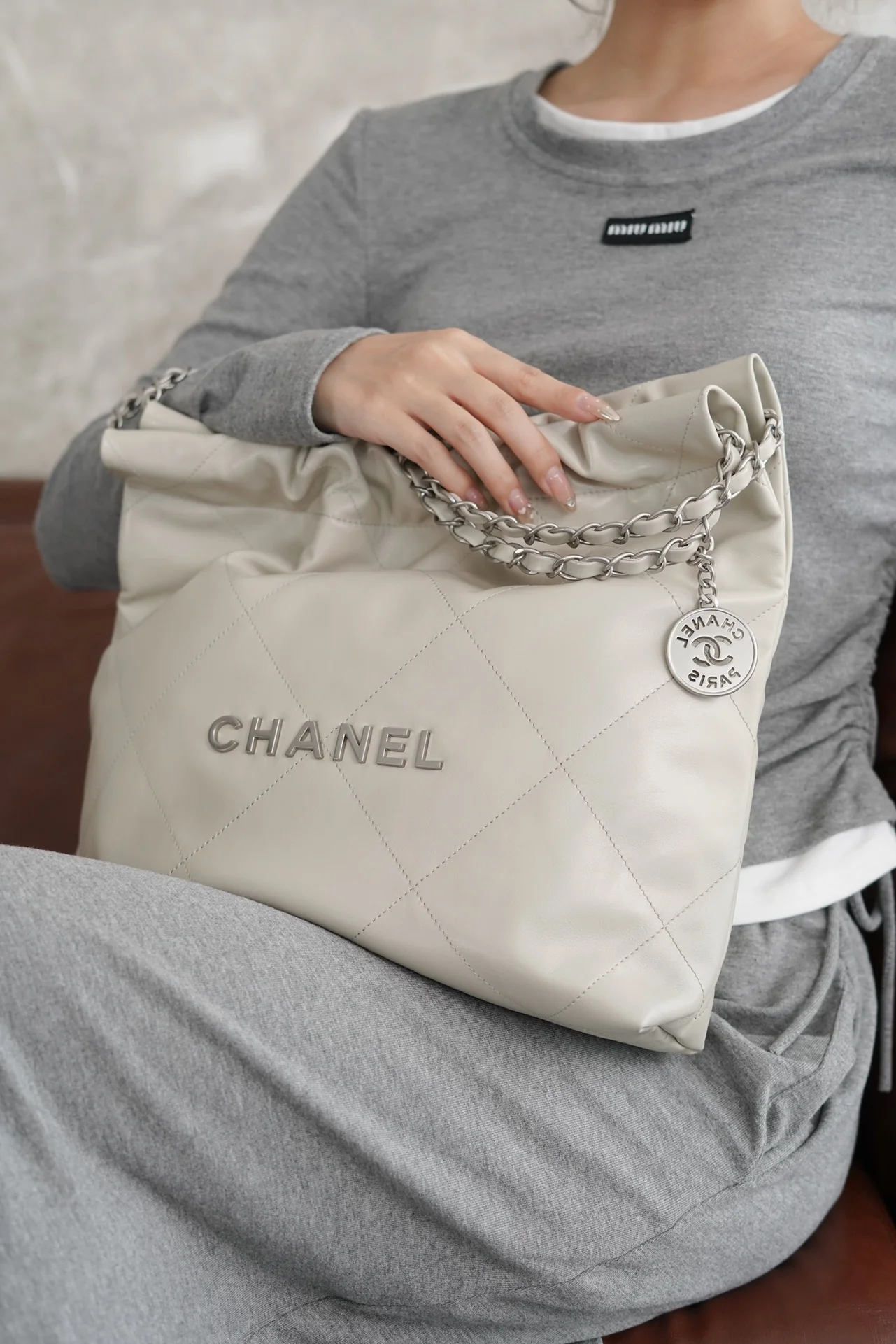 Маленькая белая сумочка Chanel с серебряной пряжкой на задней части.