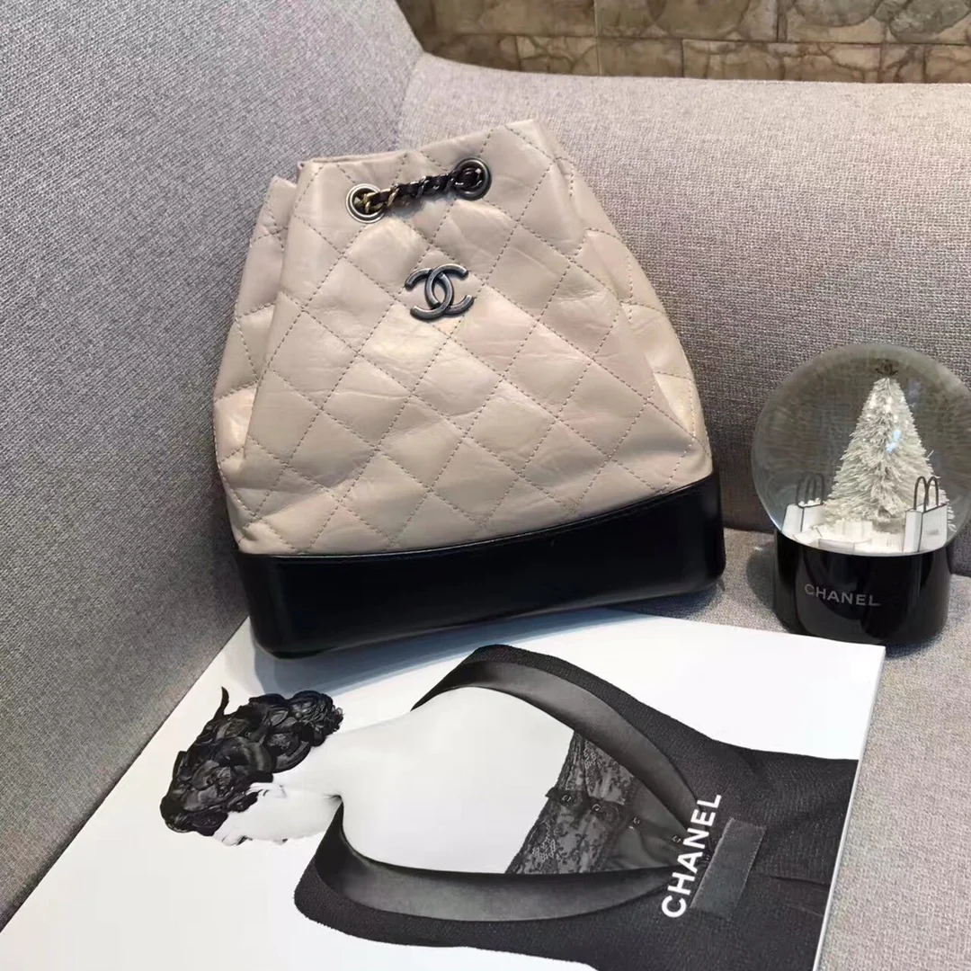 Маленький рюкзак-хобо Chanel — бежевый и черный.