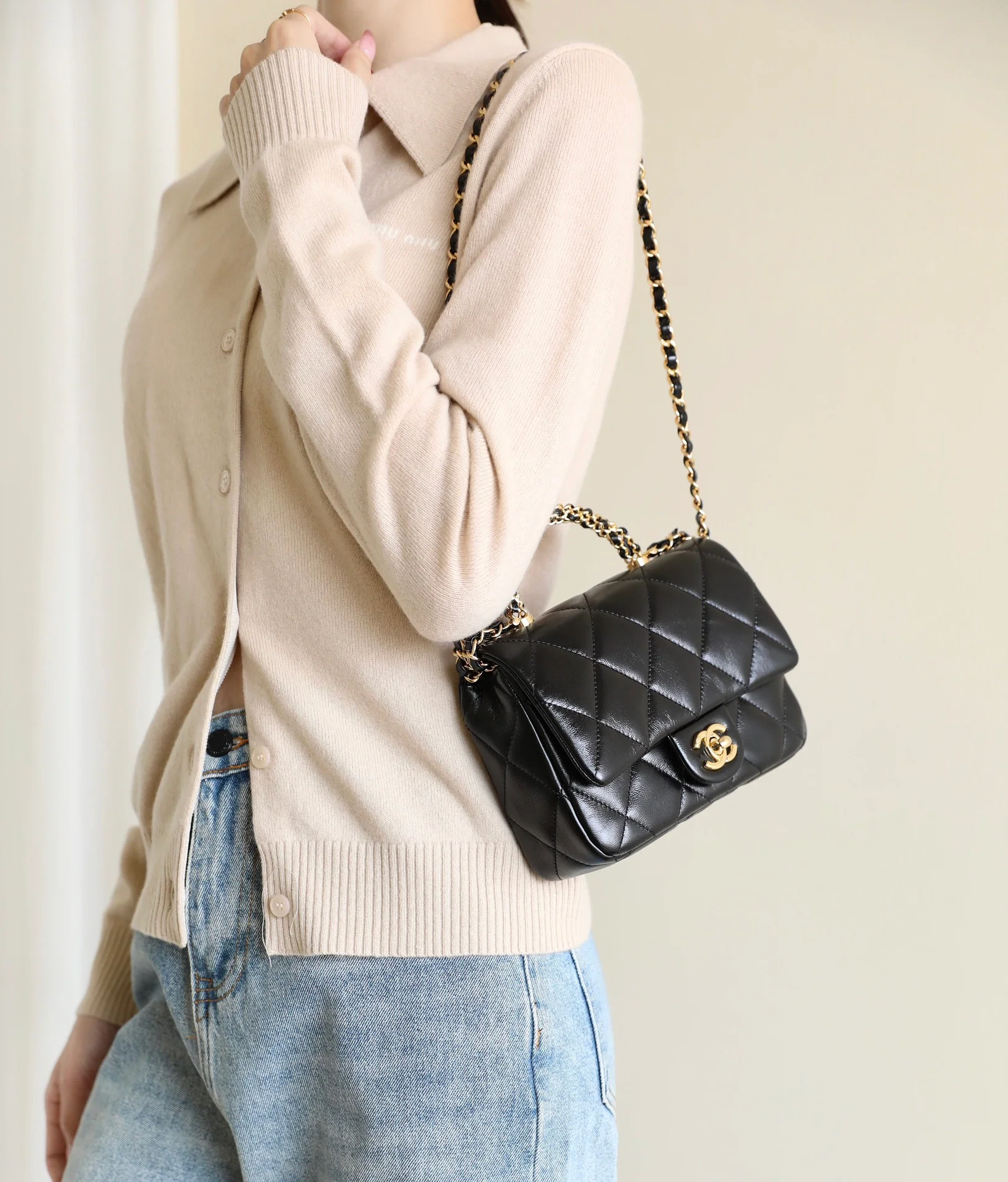Маленькая черная сумка Chanel с клапаном и поворотной ручкой.