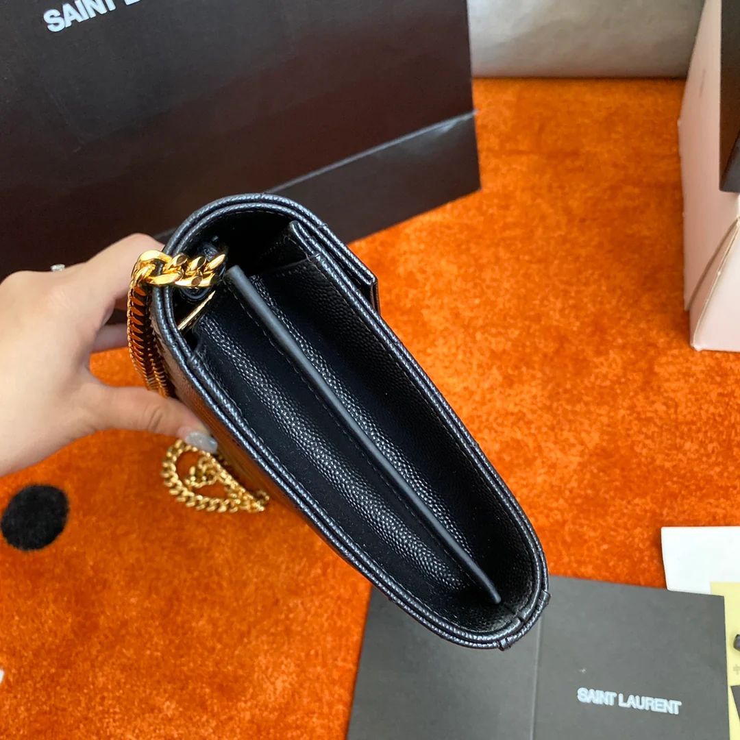 Сумка-конверт YSL с монограммой из икры — черная с золотой фурнитурой.