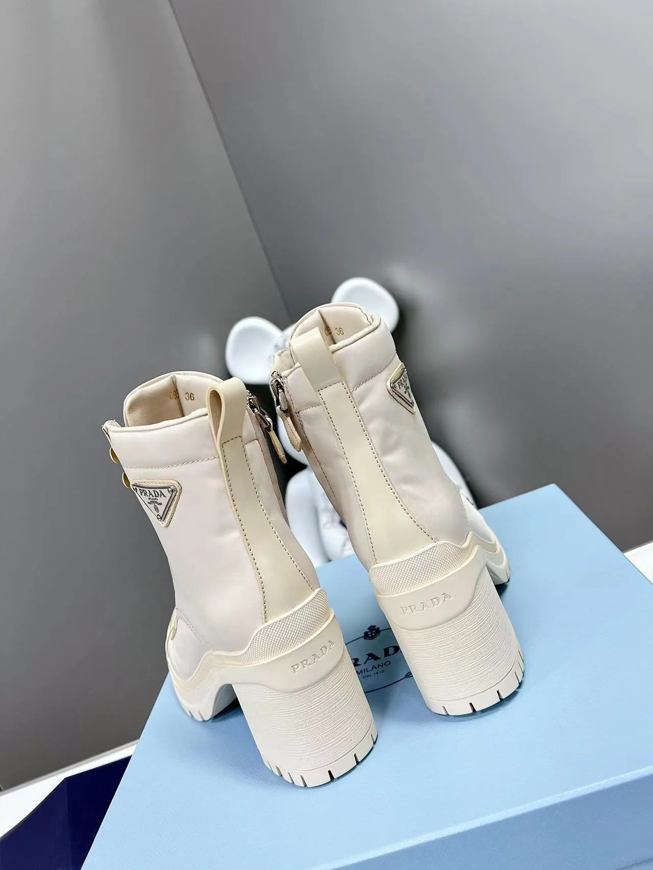 Новинка весны 2022 года от Prada: ботильоны на шнуровке и массивном каблуке — белые.