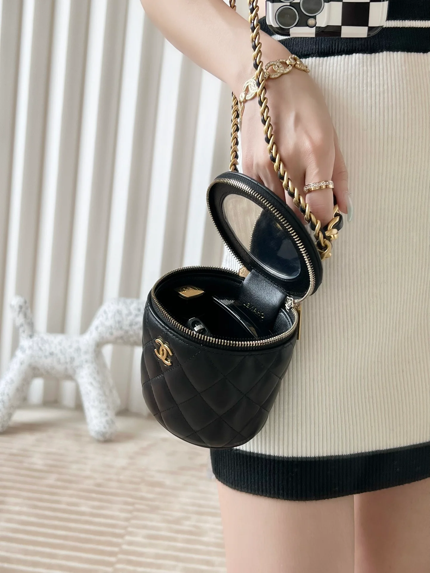 Миниатюрная кожаная сумка-ведро Chanel Métiers d'Art с цепочкой на ручке — фото в действии.