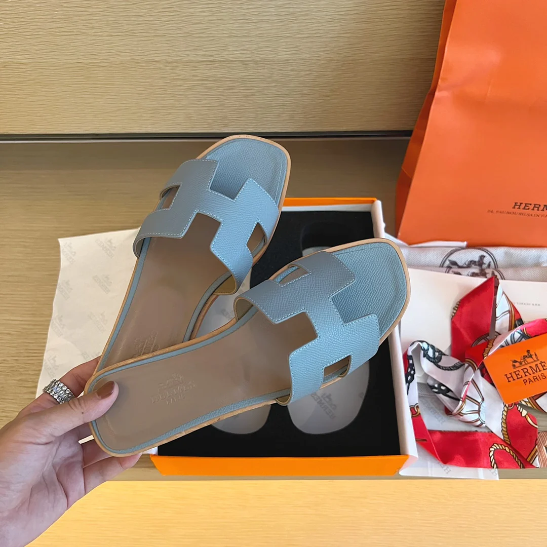 Классические тапочки Hermes с буквой H — светло-голубые с принтом пальм.