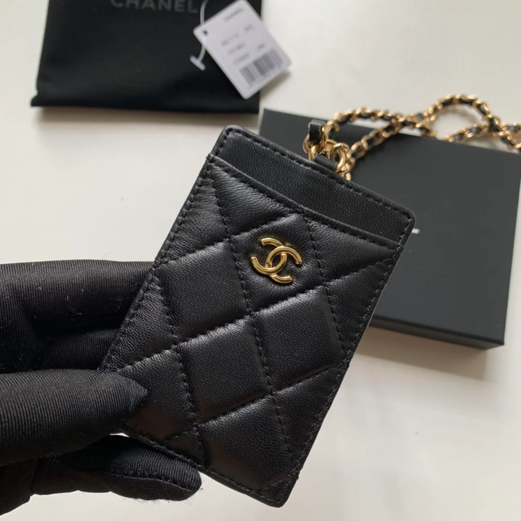 Держатель для удостоверений личности Chanel — из черной овечьей кожи с золотой пряжкой.