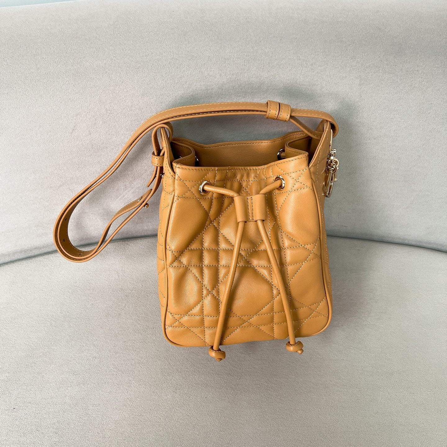 Сумка-ведро Dior Motion, маленькая, карамельно-оранжевого цвета.