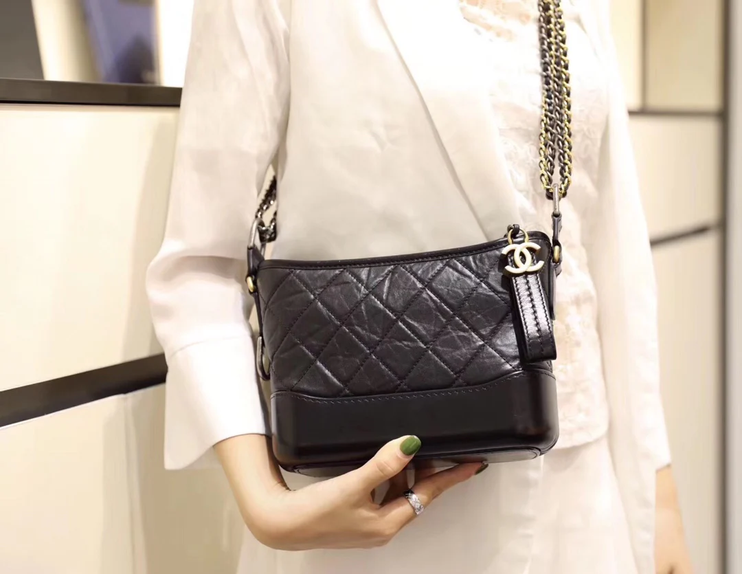 Маленькая сумка-хобо Chanel — черная, стеганая.