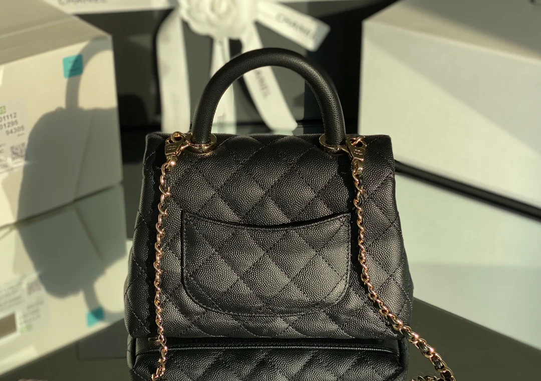 Мини-сумка Chanel Coco Handle — черная кожа с золотистой пряжкой.
