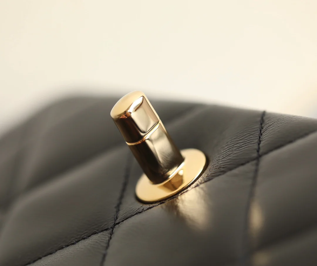 Маленькая черная сумка Chanel с клапаном и поворотной ручкой.