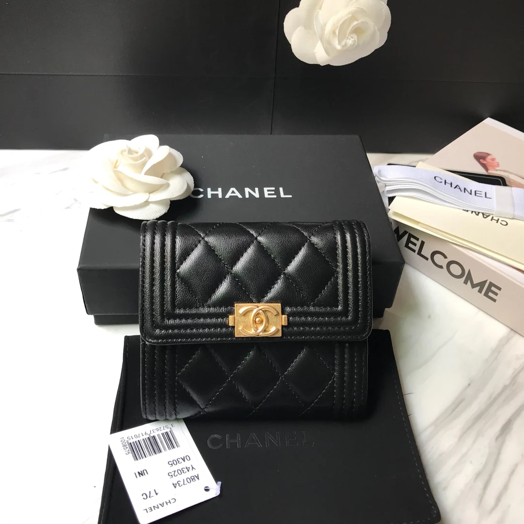 Кошелек Chanel Le Boy Tri-fold Wallet — из черной овечьей кожи с золотой пряжкой.