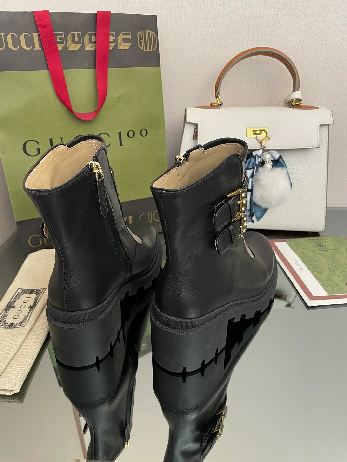 Сапоги Gucci на массивном каблуке до середины икры с монограммой — черные и бежевые.