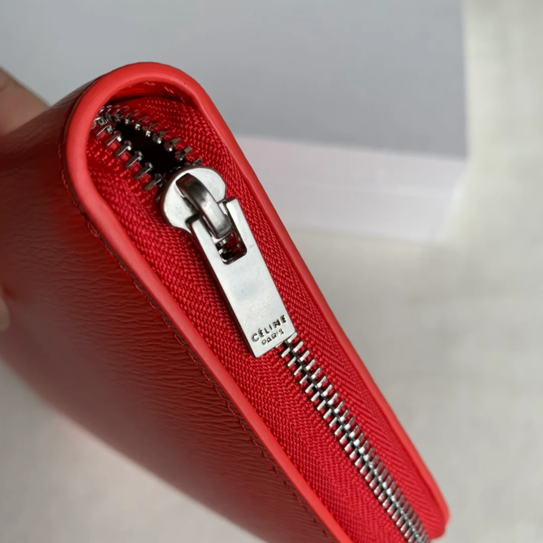 Кошелек Celine с длинной молнией — оранжево-красный узор в виде ряби на воде.