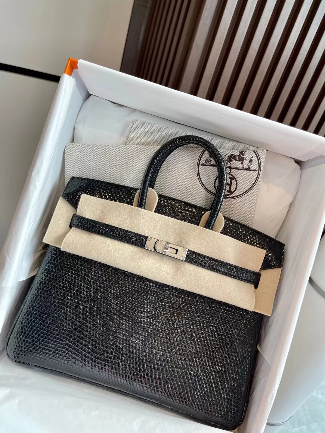 Сумка Hermes Birkin 25 из кожи ящерицы, черная, с серебряной пряжкой.