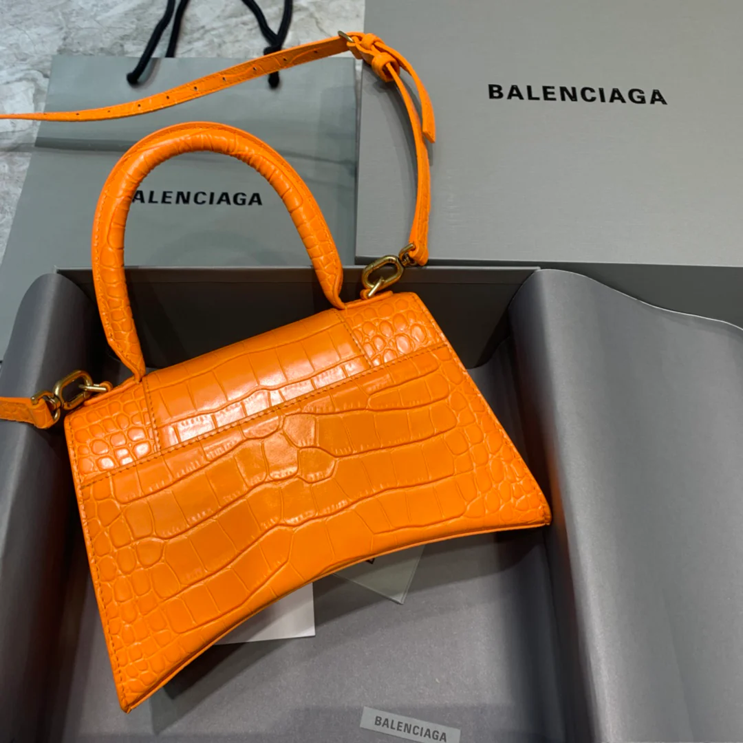 Сумка Balenciaga Hourglass — оранжевая с тиснением под крокодиловую кожу и золотой пряжкой.