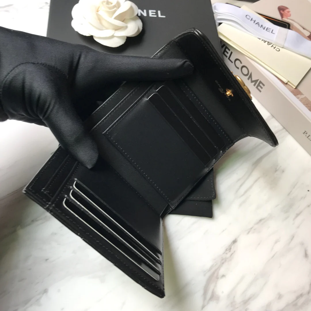 Кошелек Chanel Le Boy Tri-fold Wallet — из черной овечьей кожи с золотой пряжкой.