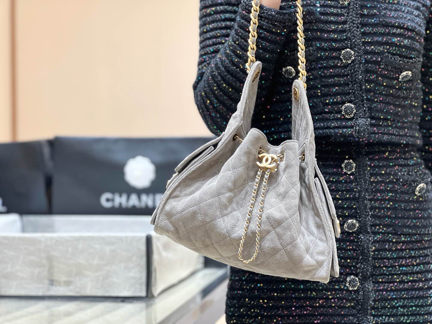 Популярная сумка-хобо Chanel 25c, которую можно носить под мышкой — серо-коричневая.