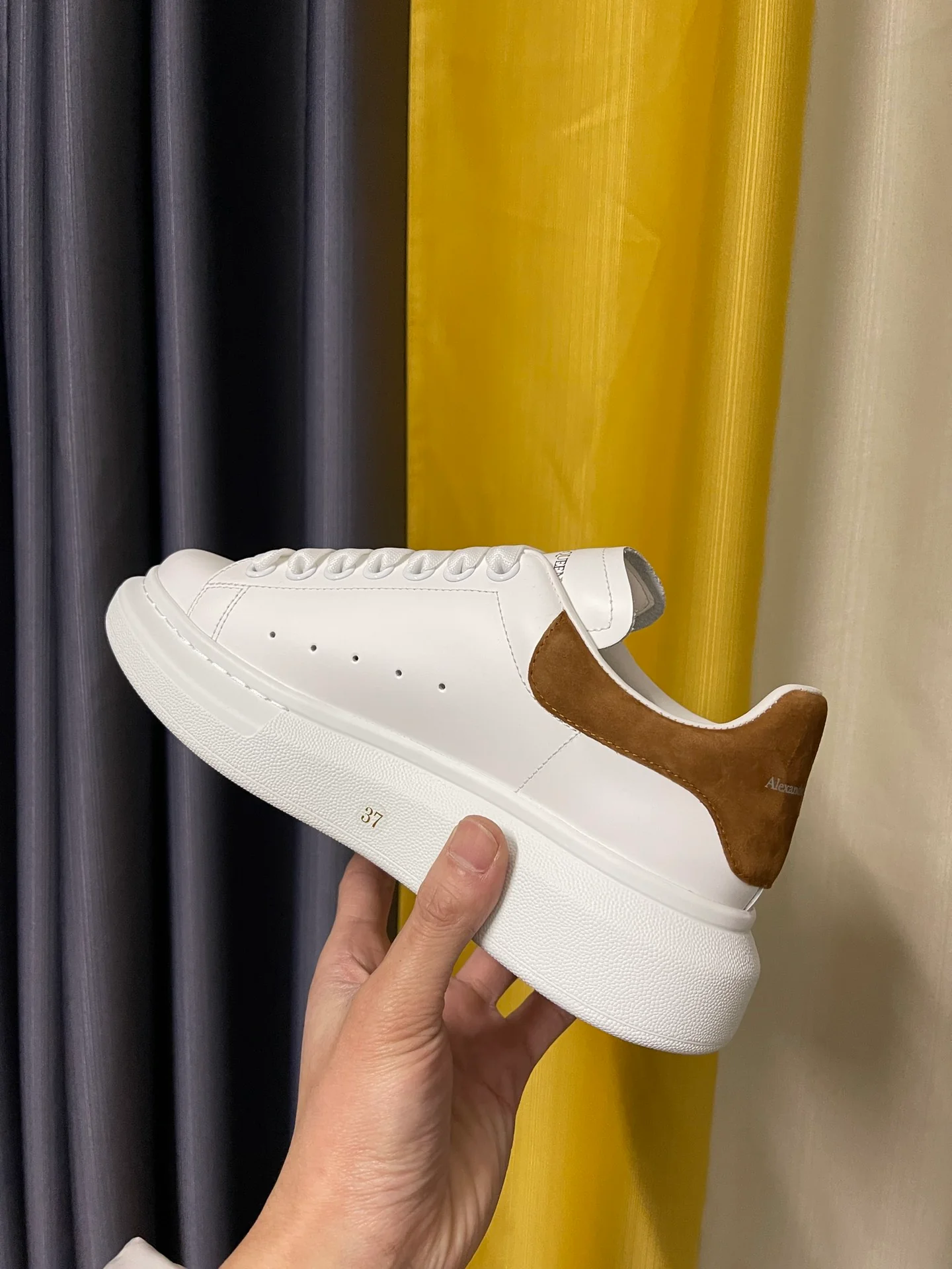 Классические белые кроссовки McQueen с коричневой замшевой подошвой на каблуке.