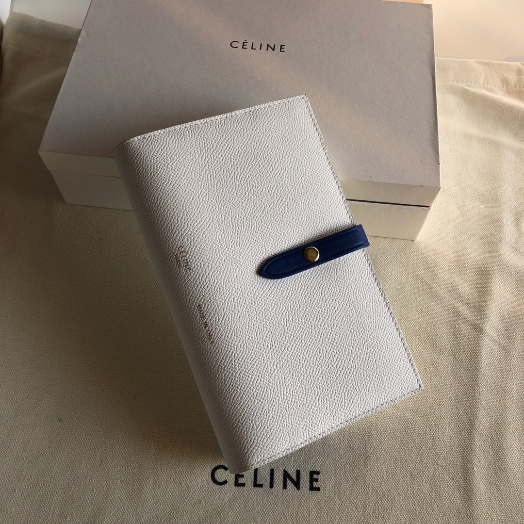 Длинный кошелек Celine — кремовый и синий — с принтом в виде пальмовых листьев.