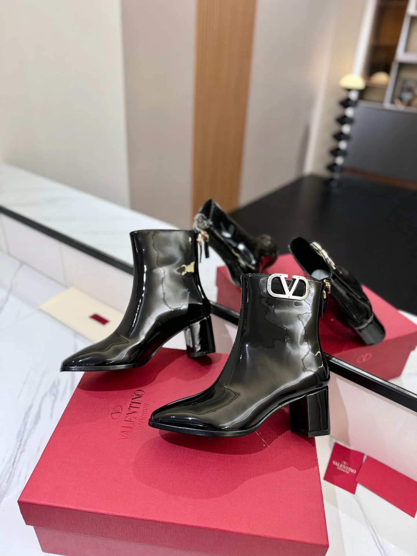 Ботильоны на высоком каблуке из лакированной кожи Valentino 2024 года — черные.