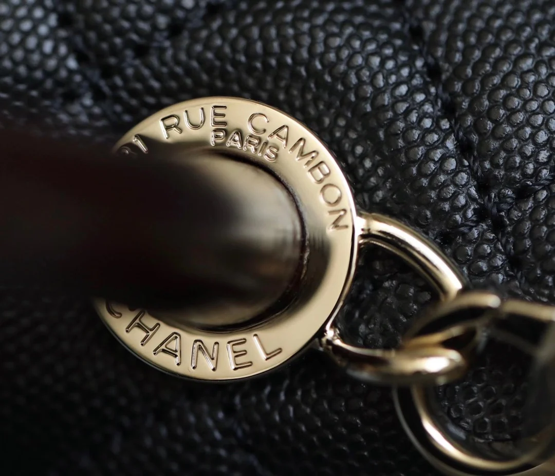 Мини-сумка Chanel Coco Handle — черная кожа с золотистой пряжкой.