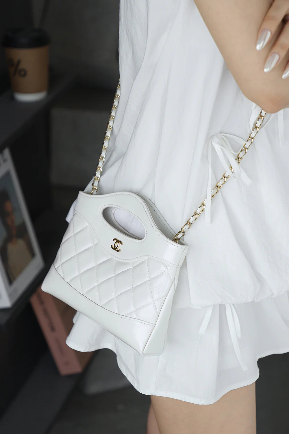 Сумка Chanel Nano 31, горизонтальный вариант, белая с пряжкой из светло-золотистого металла.