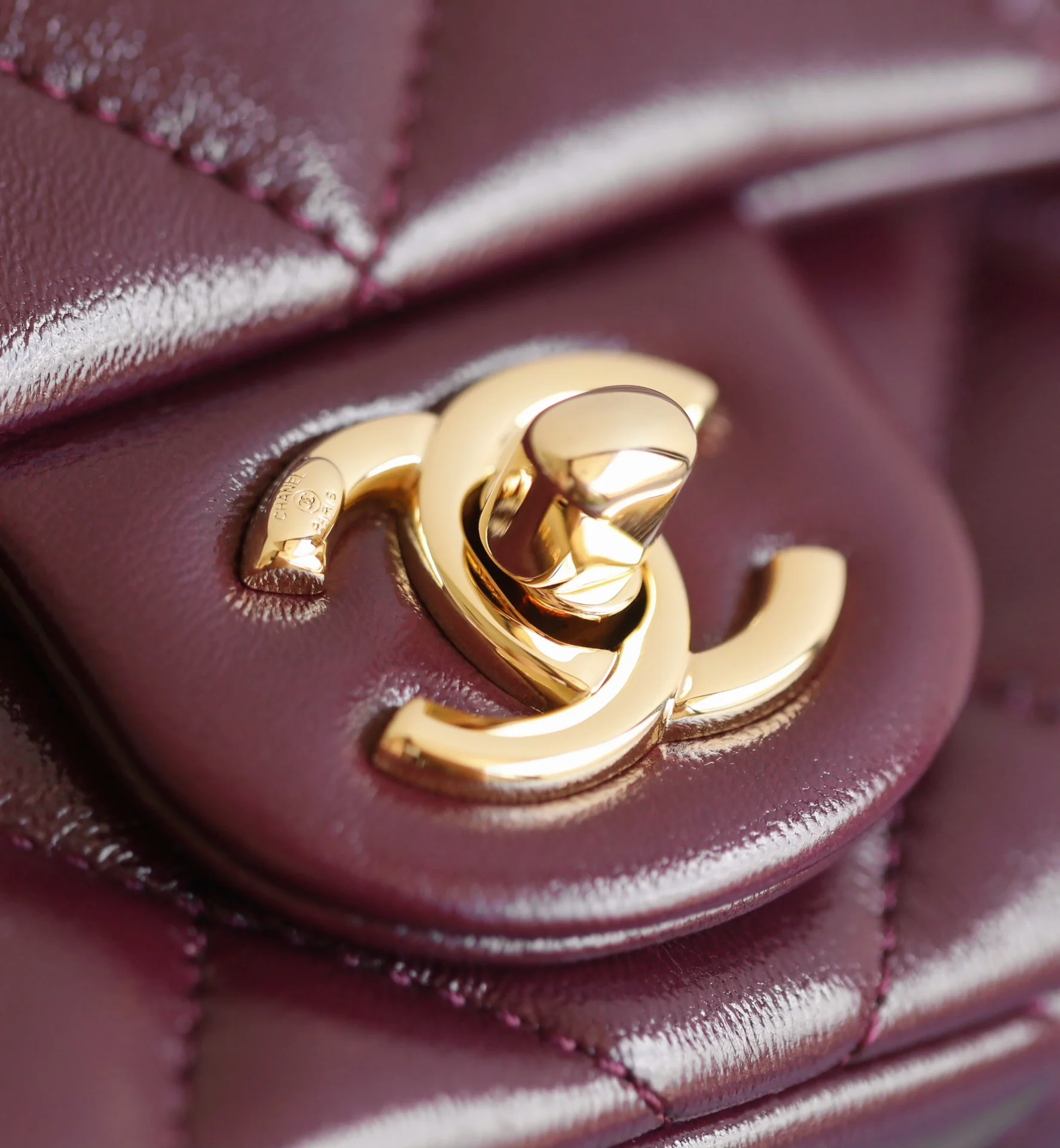 Маленькая бордовая сумочка Chanel с клапаном и привинчивающейся ручкой.