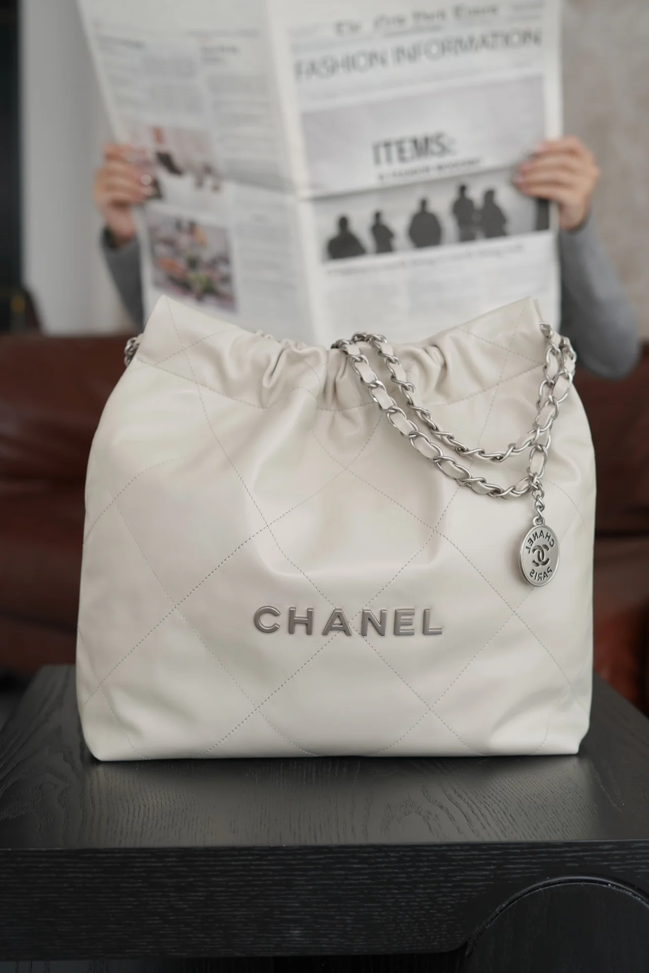 Маленькая белая сумочка Chanel с серебряной пряжкой на задней части.