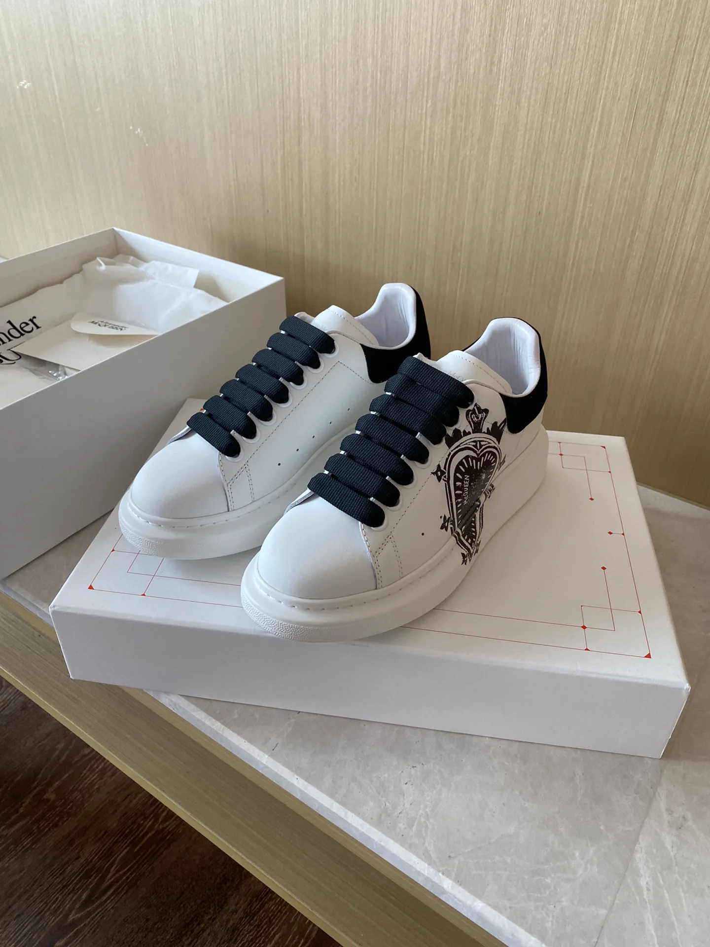 Классические белые кроссовки McQueen с рисунком в виде сердечек на верхней части.