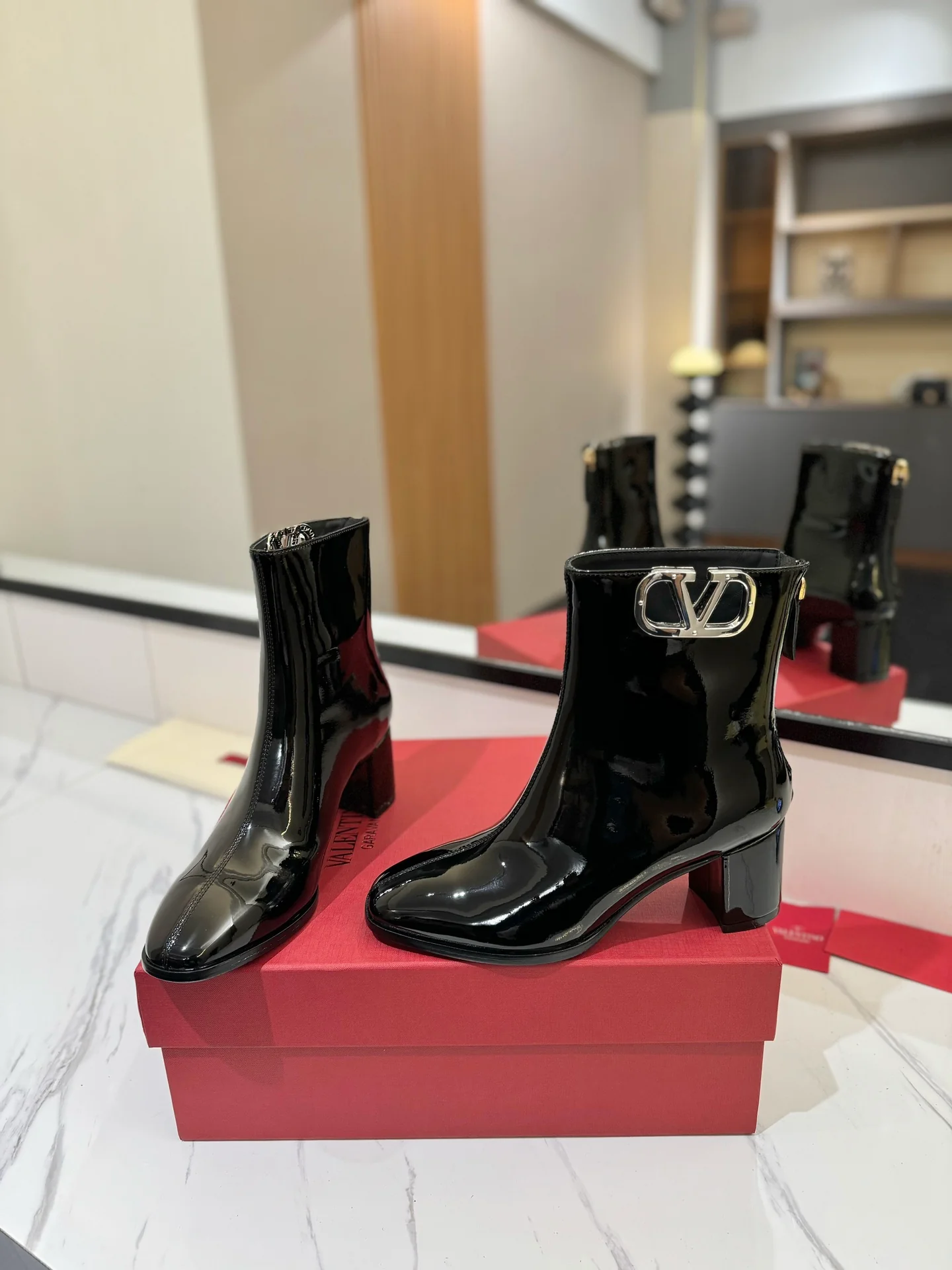 Ботильоны на высоком каблуке из лакированной кожи Valentino 2024 года — черные.