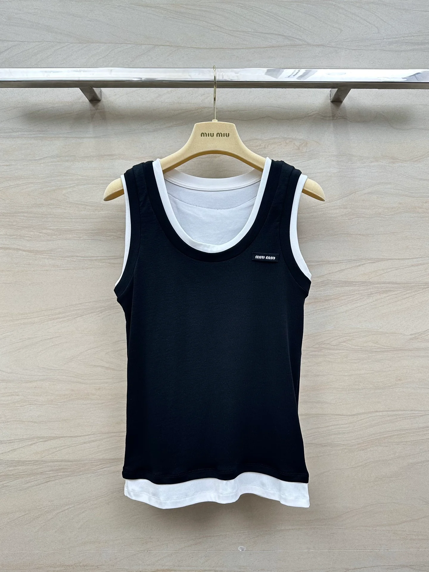 Новинка сезона весна/лето 2024 от Miu Miu: многослойный, культовый универсальный жилет — черный.